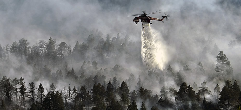 Helicopter dropping water on forest fire